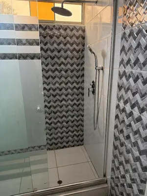 a shower with a glass door in a bathroom at Loft and reception RISHEL in Chincha
