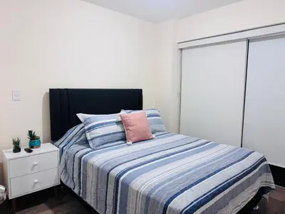 a bedroom with a bed with a pink pillow on it at Monterrico Polo Aparts #22- Dpto 2 Dorm 2 baños - Frente Embajada USA in Lima