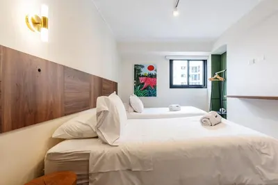 two beds in a bedroom with white walls at Bagheera 2BR by Geko in Lima