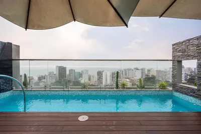 a swimming pool with a view of a city at Stelar by Geko in Lima