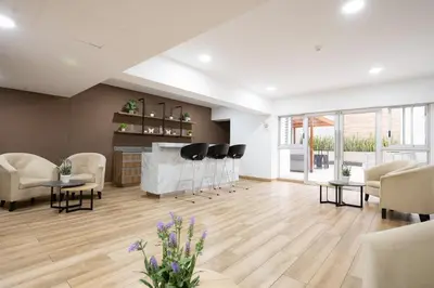 a large living room with chairs and a fireplace at The Rooftop 2BR by Geko in Lima