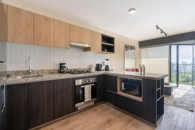 a kitchen with wooden cabinets and a large window at Miraflores Modern Apartments Benavides by Geko in Lima