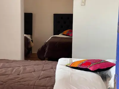 a bedroom with a bed and a mirror at Auquis Hostel in Cusco