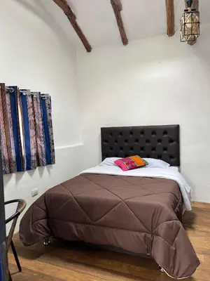 a bedroom with a bed with a black headboard at Auquis Hostel in Cusco