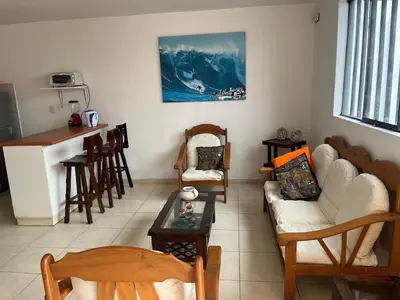 a living room with a couch and chairs and a table at Punta Hermosa - depa Santa Cruz in Punta Hermosa