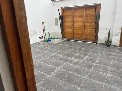 a garage with a wooden door and a tile floor at Punta Hermosa - depa Santa Cruz in Punta Hermosa