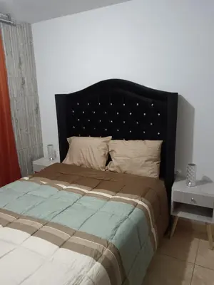 a bed with a black headboard in a bedroom at Departamento Vista al Parque Coopip in Lima