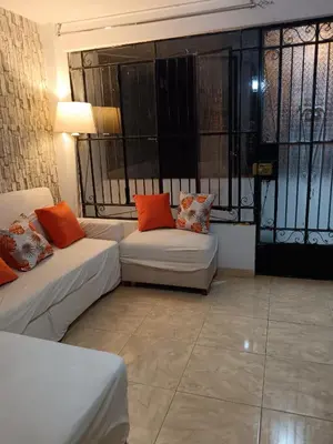 a living room with two white couches and orange pillows at Departamento Vista al Parque Coopip in Lima