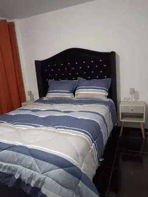 a bedroom with a bed with blue and white sheets at Departamento Vista al Parque Coopip in Lima