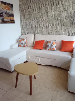 a living room with a white couch and a table at Departamento Vista al Parque Coopip in Lima