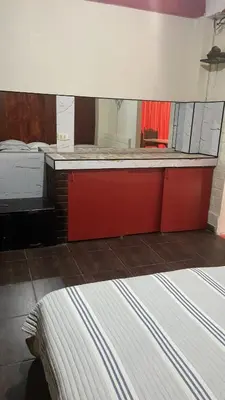 a room with two beds and a large mirror at Residencial Misky Dreams in Huánuco