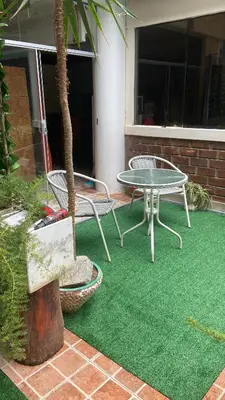 a patio with a table and chairs and a tree at Residencial Misky Dreams in Huánuco