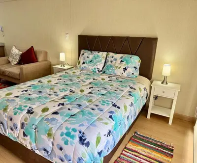 a bedroom with a large bed and a couch at Encantador departamento con hermosa vista in Lima