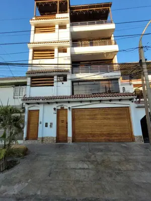 a building with two garage doors in front of it at Habitación Privada con Entrada Independiente in Ica