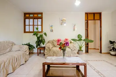 a living room with two couches and a table with flowers at casa de campo en cieneguilla in Cieneguilla