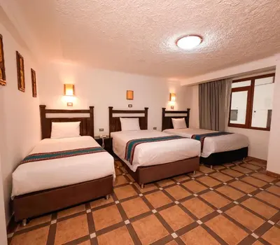 a hotel room with two beds in a room at Hotel Rojas Machupicchu in Machu Picchu