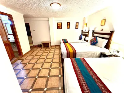 a hotel room with two beds and a tiled floor at Hotel Rojas Machupicchu in Machu Picchu