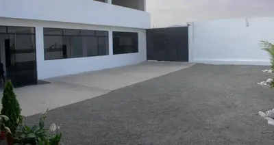 an empty garage in a building with black doors at Kampu Wasi - Casa de Campo in Pachacamac