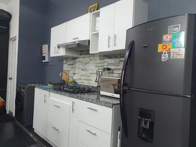 a kitchen with a black refrigerator and white cabinets at Beautiful private office in Miraflores in Lima
