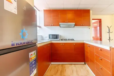 a kitchen with wooden cabinets and a refrigerator at Hostal Cusco Guest Home in Cusco