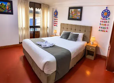 a bedroom with a large bed and two lamps at Wayna Boutique Hotel in Cusco