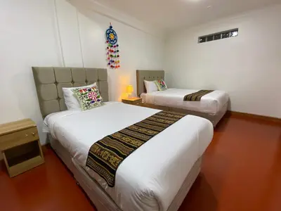 a bedroom with two beds and a table with a lamp at Wayna Boutique Hotel in Cusco