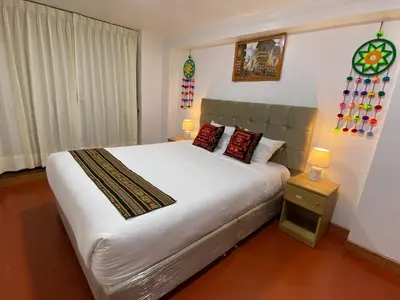 a bedroom with a large white bed with two pillows at Wayna Boutique Hotel in Cusco