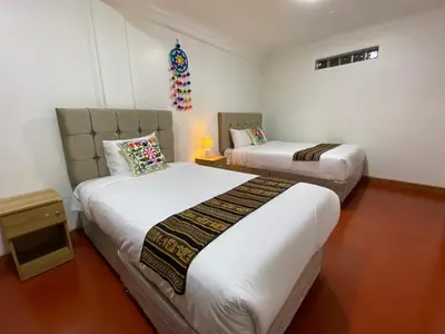 a bedroom with two beds and a table with a lamp at Wayna Boutique Hotel in Cusco