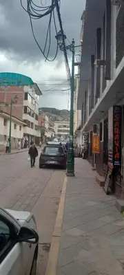 a street with cars parked on the side of the road at Hospedaje M&M in Cusco