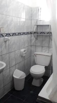 a white bathroom with a toilet and a sink at Hospedaje M&M in Cusco