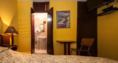 a hotel room with a bed and a bathroom at Hostal Iquique in Lima