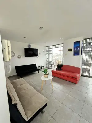 a living room with a red couch and a table at Departamento en Playa San Bartolo Con terraza in San Bartolo