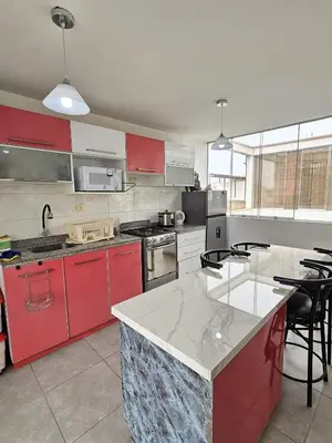 a kitchen with red cabinets and a white counter top at Departamento en Playa San Bartolo Con terraza in San Bartolo