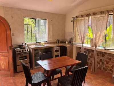 a kitchen with a wooden table and chairs and a stove at Country house cieneguilla in Cieneguilla