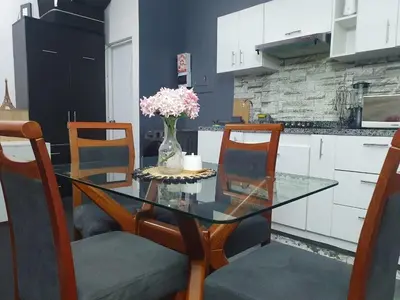 a glass table with a vase of flowers in a kitchen at Hermosa oficina privada en Miraflores in Lima