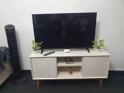 a tv on top of a white cabinet with plants at Hermosa oficina privada en Miraflores in Lima