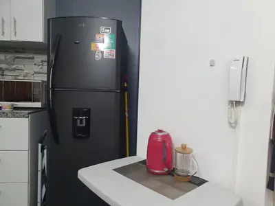 a black refrigerator in a kitchen with a counter at Hermosa oficina privada en Miraflores in Lima