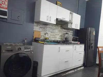 a kitchen with white cabinets and a refrigerator at Hermosa oficina privada en Miraflores in Lima