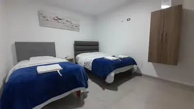 two beds in a room with blue and white sheets at La Rinconada de Churin in Churín