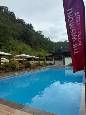 a large blue swimming pool with a sign next to it at The Wismont club & hotel in La Merced