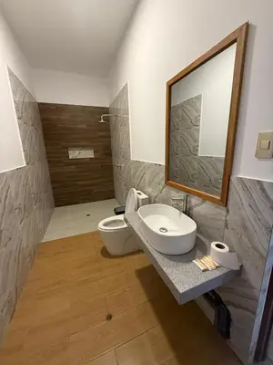 a bathroom with a sink and a toilet and a mirror at The Wismont club & hotel in La Merced