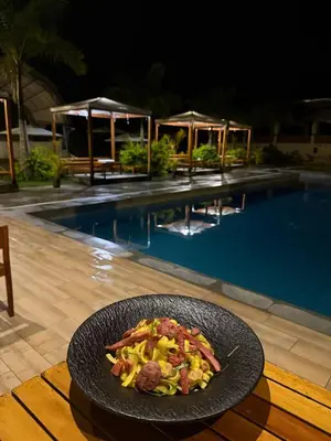 a plate of food on a table next to a swimming pool at The Wismont club & hotel in La Merced