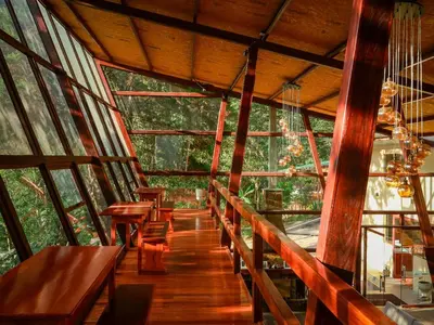 a room with wooden tables and benches in a tree house at Ecoterra Inka Lodge in Quillabamba
