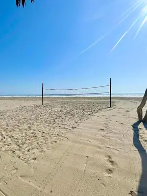 a person standing on a beach with a volleyball net at Bungalows en playa Wakama in San Vicente de Cañete