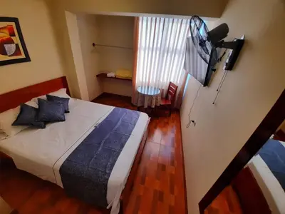 a bedroom with a bed and a flat screen tv at Hotel Wismont Piñales in La Merced