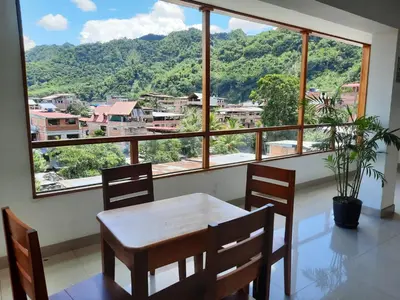 a dining room with a table and chairs and a large window at Hotel Wismont Piñales in La Merced