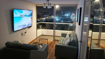 a living room with a couch and a flat screen tv at Departamento con Vista al Mar San Miguel in Lima