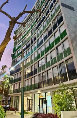 a tall building with green windows and a street light at Rest, comfort and privacy in San Isidro in Lima