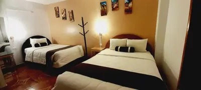a room with two beds in a room at El Tambo Machupicchu in Machu Picchu