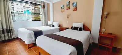 a hotel room with two beds and a window at El Tambo Machupicchu in Machu Picchu